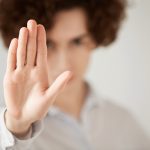Close up isolated shot of woman with short brunette hair making stop gesture with her hand. Female entrepreneur showing stop sign, not wanting to continue business talks. Selective focus on the hand